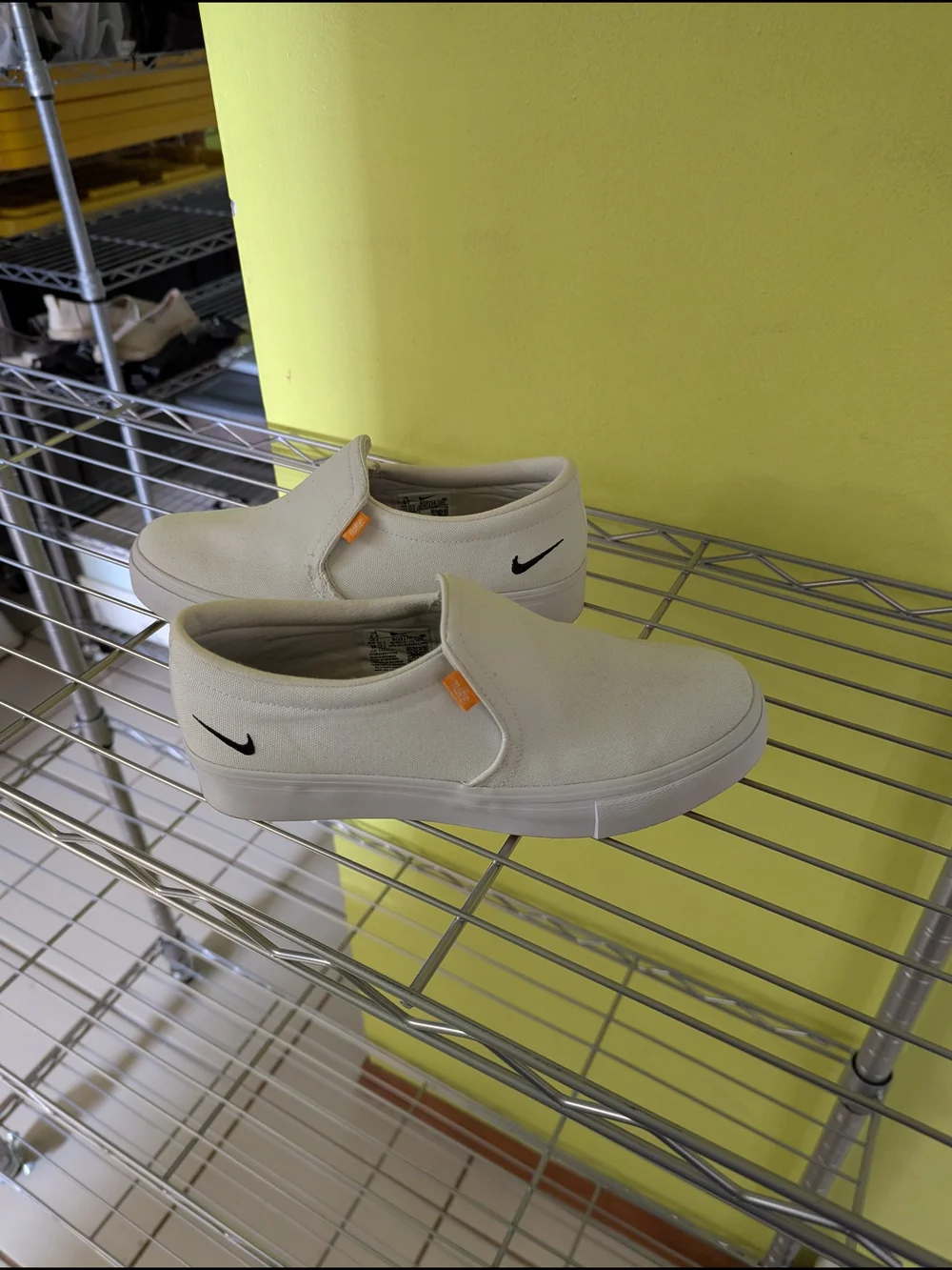 Nike White Slip-On Canvas Sneakers with Black Swoosh and Orange Tabs